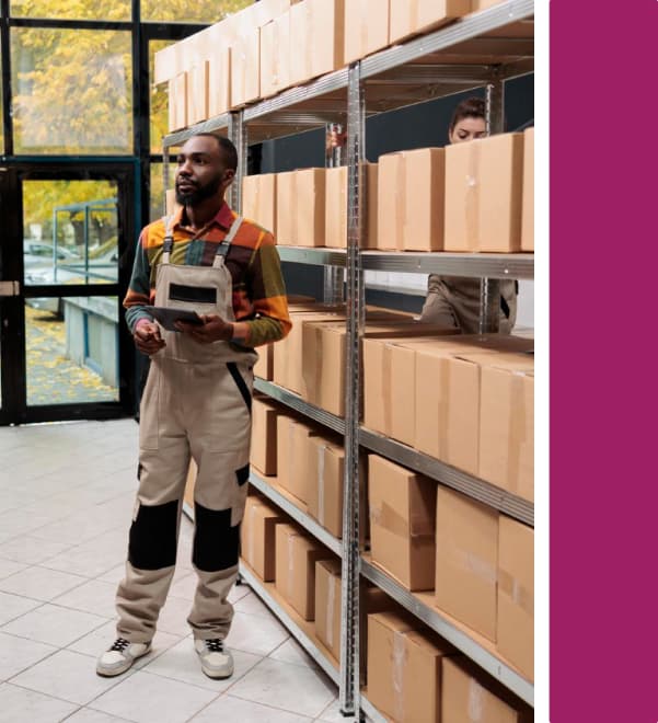 Warehouse worker with tablet checking stock on shelving racks