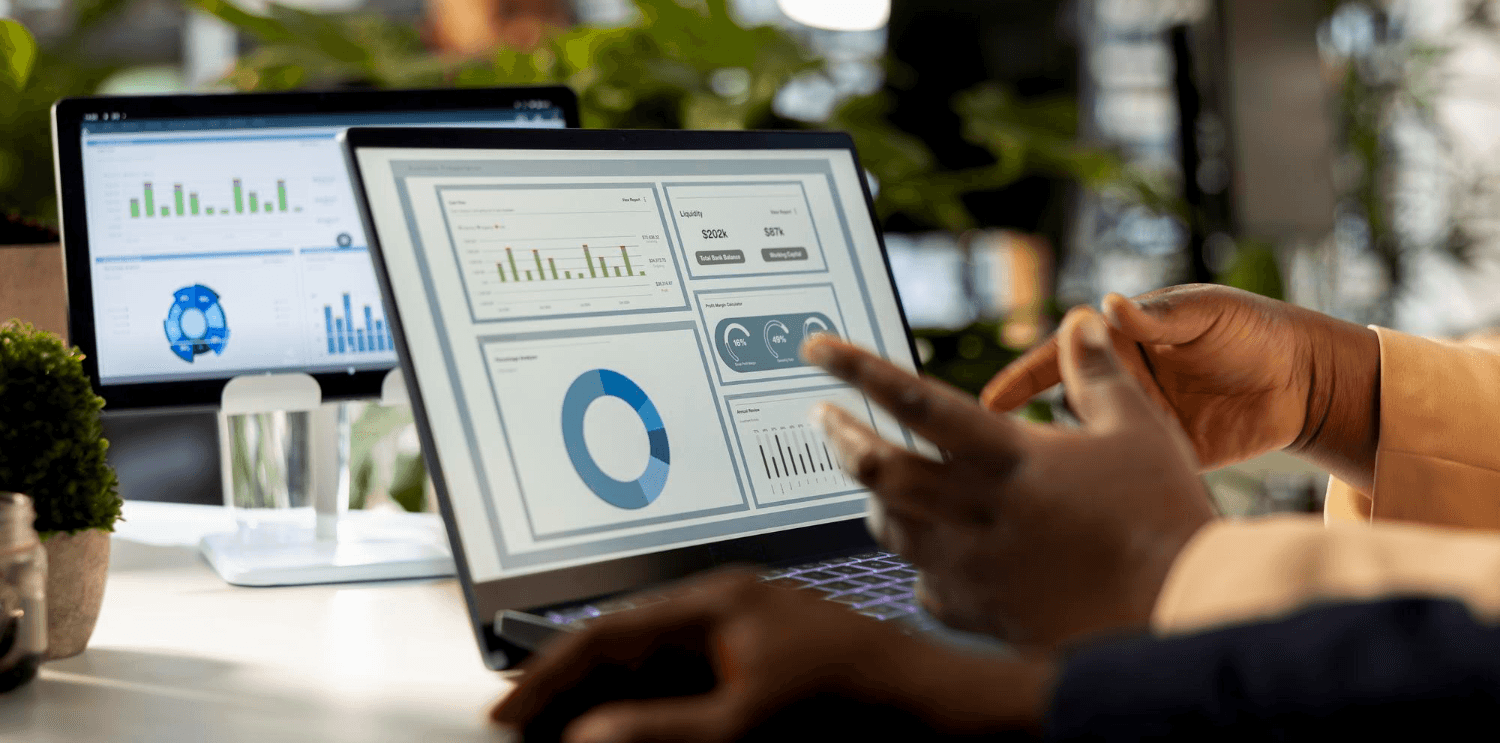 Business analysts reviewing Salesforce CRM dashboards on dual monitors